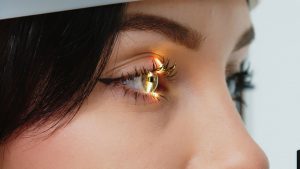 Nahaufnahme eines Auges während einer Augenlaser-Behandlung, bei der ein präziser Laserstrahl die Hornhaut zur Korrektur einer Fehlsichtigkeit formt